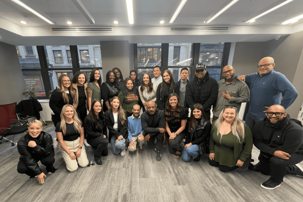 Group photo of diverse marketing professionals gathered in a modern office setting, showcasing teamwork and collaboration within the CNV Creative agency.
