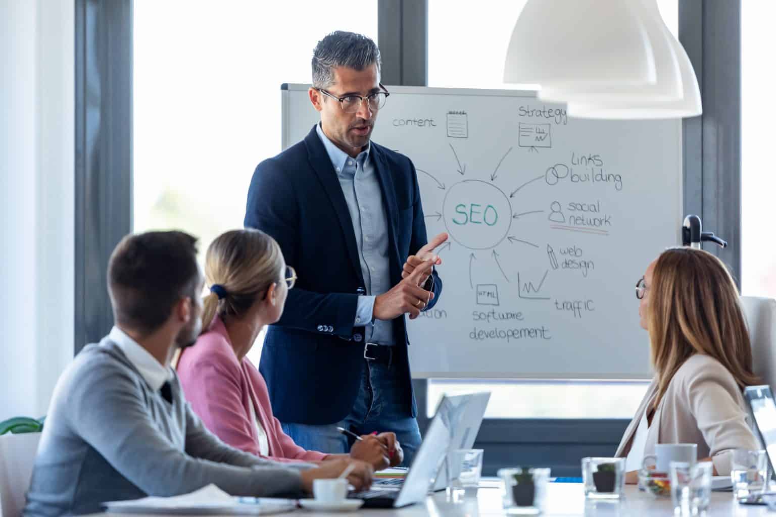 Man presenting SEO strategy and digital marketing concepts to team.